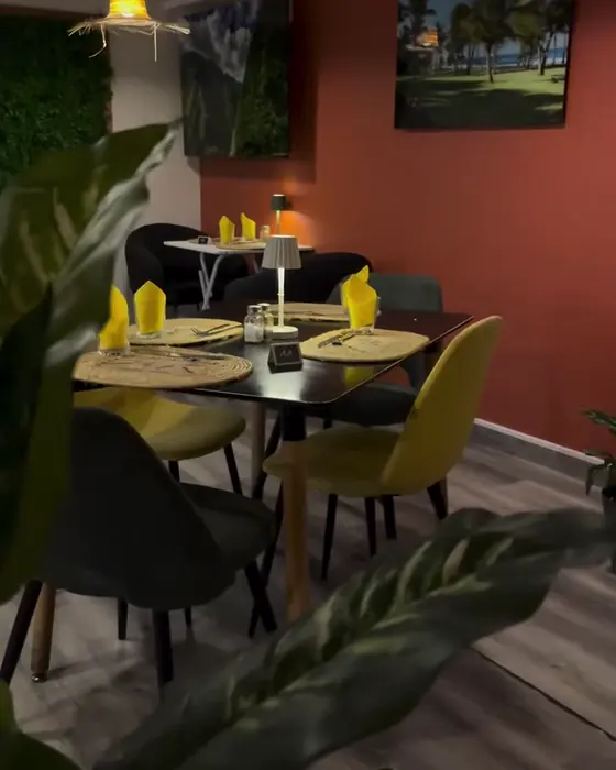 Le nouveau décor du soir : mur terracotta, chaises en velours moutarde, suspensions en chapeau de paille
